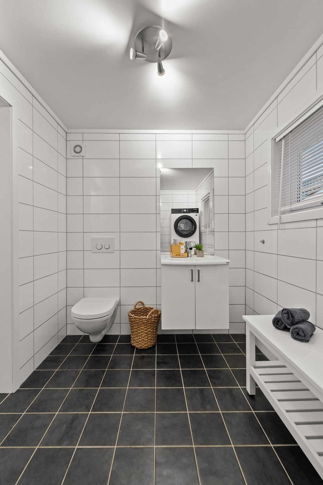 Det er lyse veggfliser og himling, samt mørkere gulv med varme. Galleribilde