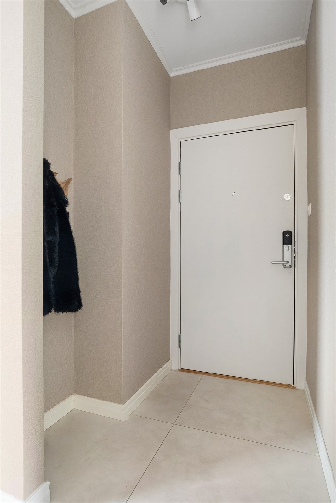 Leiligheten har en lys og innbydene entré, som gir et godt førsteinntrykk. Her er det praktisk oppheng til yttertøy. Galleribilde