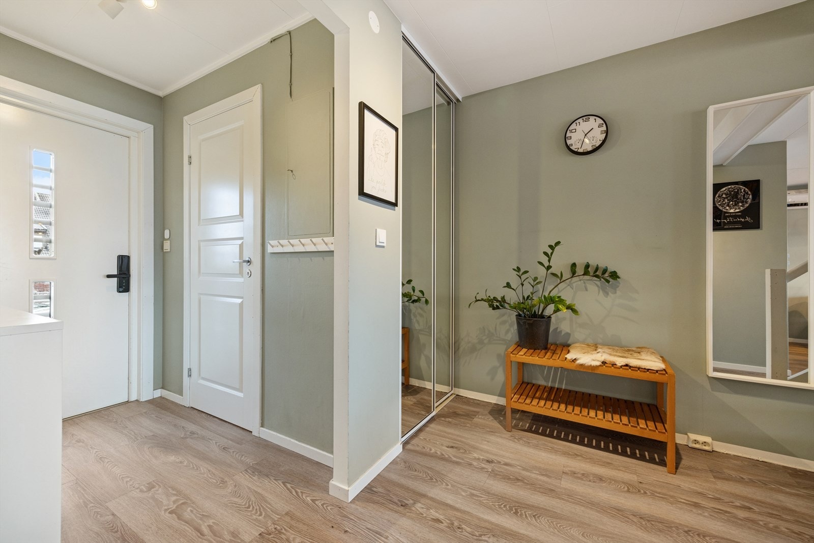 Velkommen inn! Lys entré med plass til å henge fra seg yttertøy samt skyvedørsgarderobe rundt hjørnet. Galleribilde