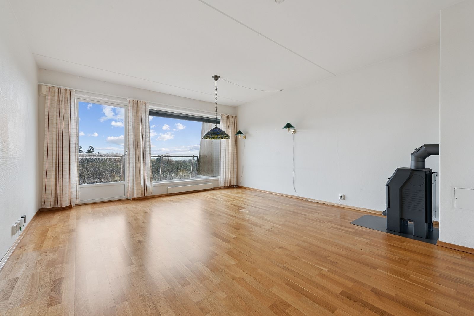 Stue med utgang til balkong og peisovn Galleribilde