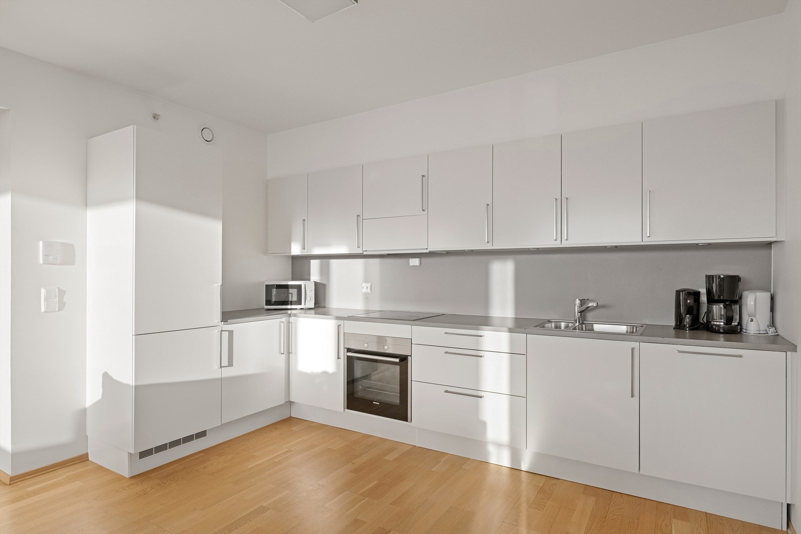 Pent, lyst kjøkken med integrerte hvitevarer Galleribilde