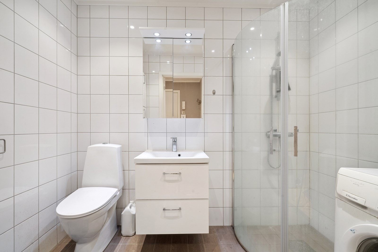 Lyst og pent bad med fliser med varme i gulv, fliser på vegger og slett malt tak m/downlights. Galleribilde