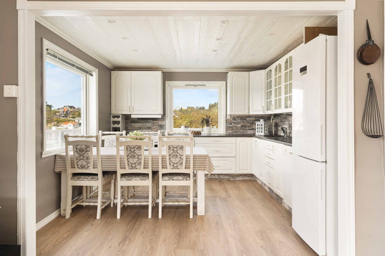 Kjøkkenet måler ca. 12 kvm og består av profilerte fronter, glasskap og laminat benkeplate med nedfelt vask av stål. Galleribilde