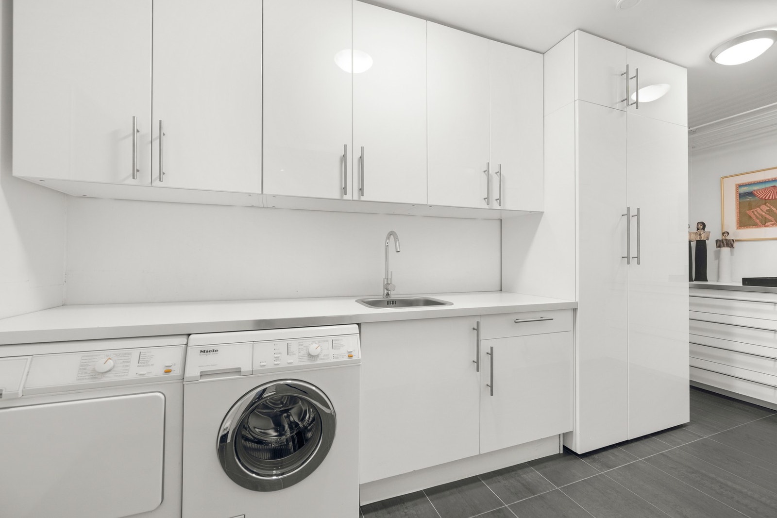 Praktisk vaskerom i 1. etasje med flislagt gulv med vannbåren gulvvarme. Galleribilde