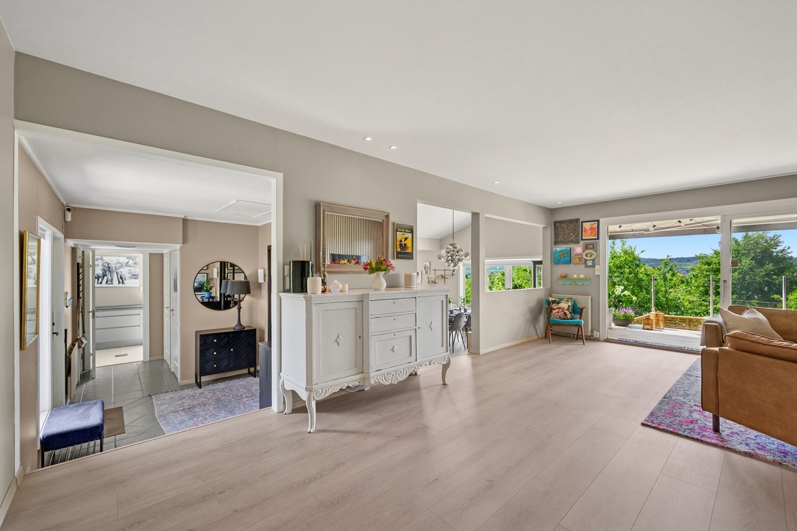 Stuen har malte vegger i en dus beigefarge, komplimentert med en hvit himling og downlightsbelysning som passer perfekt til boligens stil. Galleribilde