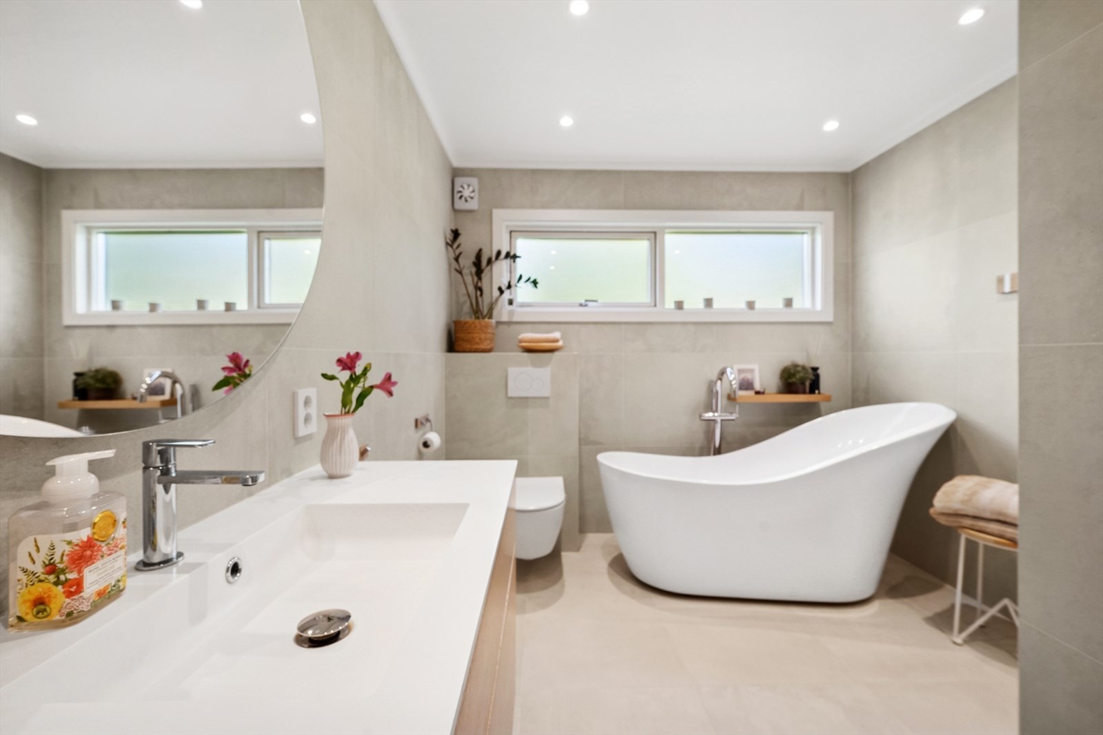 Baderommet er utstyrt med moderne innredning med enkel servant, speil med belysning, dusjnisje med dobbel dusj, badekar og vegghengt toalett. Galleribilde