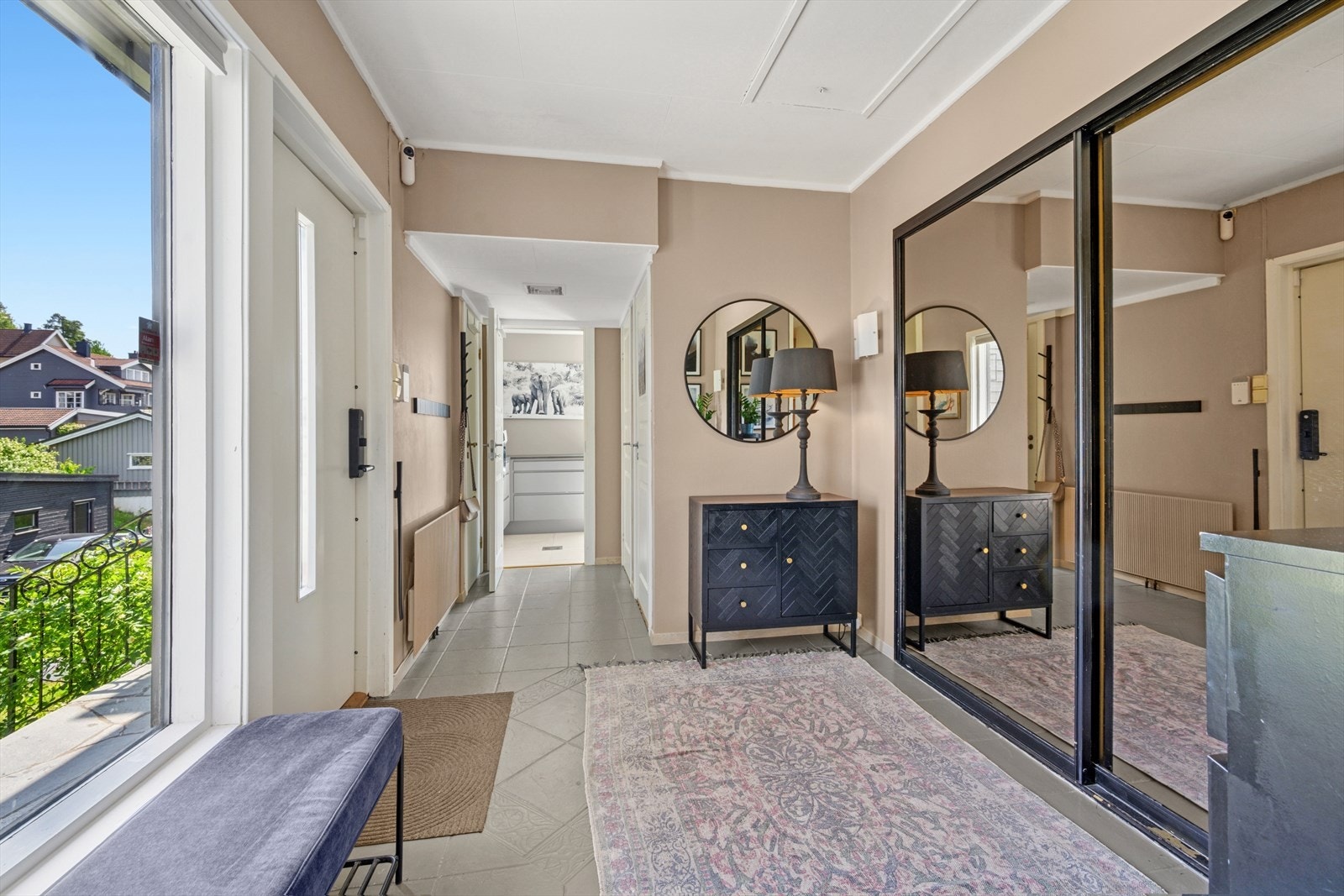 Innenfor døren i 1. etasje ønsker en romslig hall velkommen inn- Lekker skyvedørsgarderobe med speilfronter og sorte detaljer som fremmer interiøret. Galleribilde