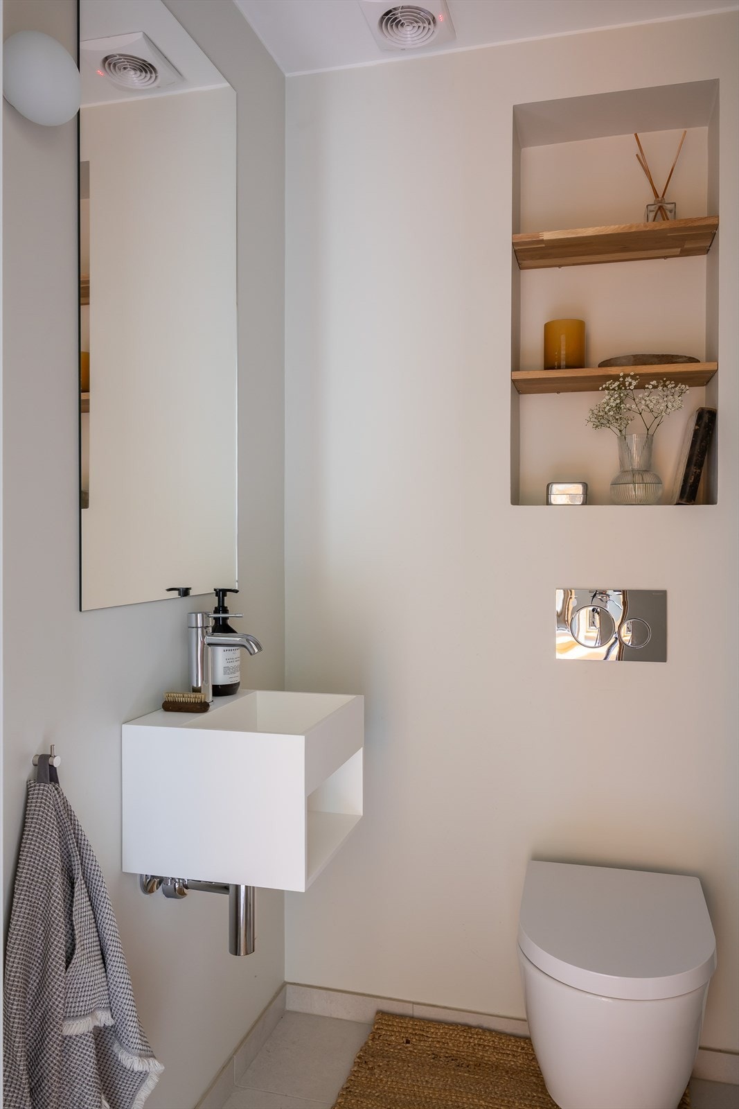 Separat toalett med vegghengt toalett, servant med underhylle, speil og lampe over servant. Flislagt gulv med varmekabler. Galleribilde