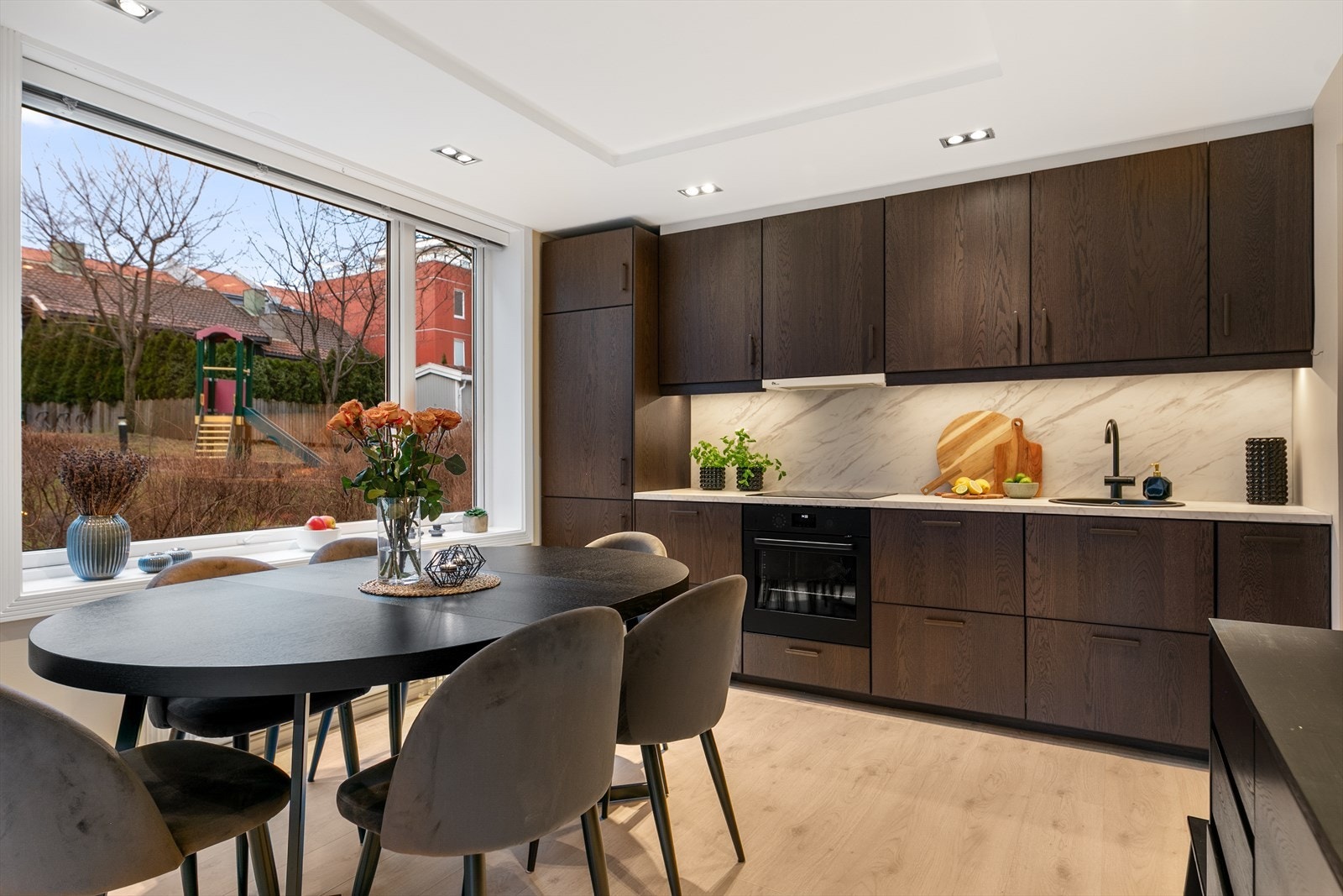 Langs den ene kortveggen i rommet ble det i 2024 montert ny, lekker kjøkkeninnredning fra IKEA. Lekre, mørke fronter og laminat benkeplate sikrer et utrykk som sklir naturlig inn i rommet. Galleribilde