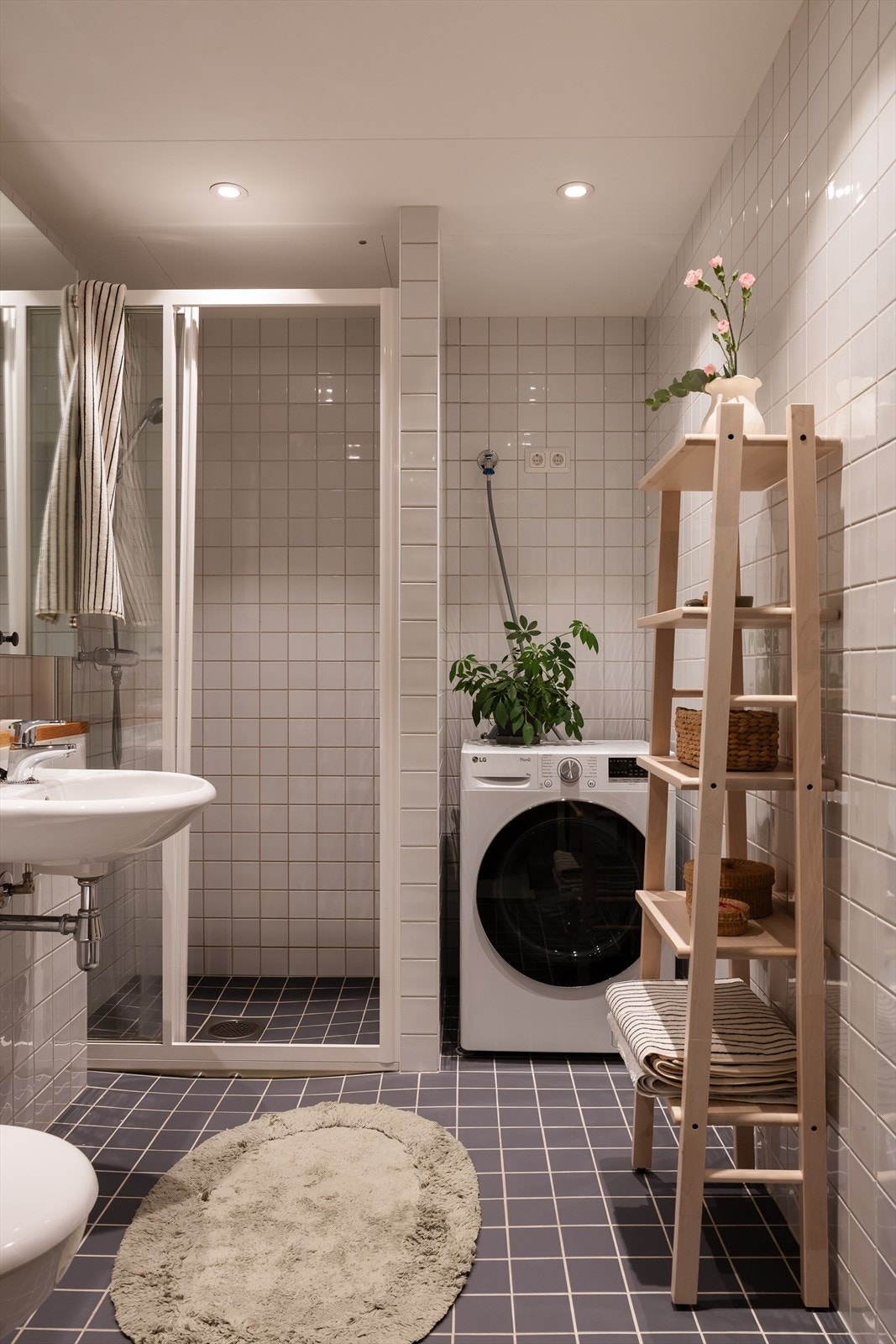 Badet er innredet med vegghengt toalett, servant og dusjhjørne med skyvbare glassdører Galleribilde