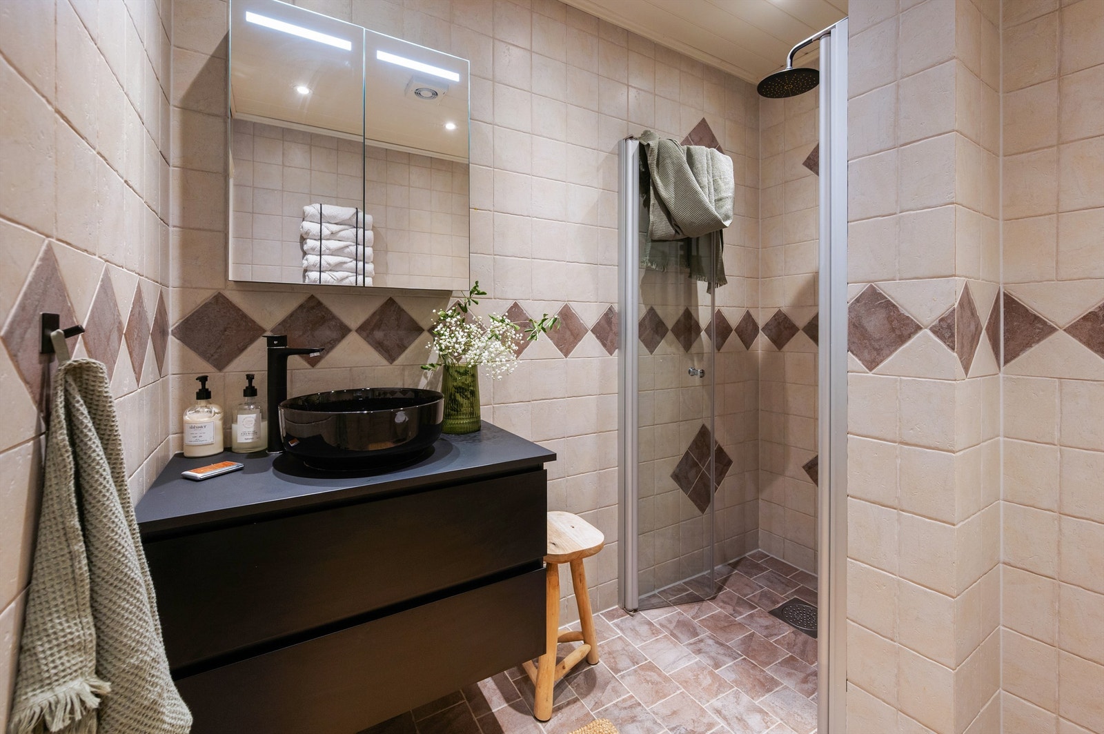 Badet har vegghengt toalett og en dusjnisje med innfellbare dører i herdet glass Galleribilde