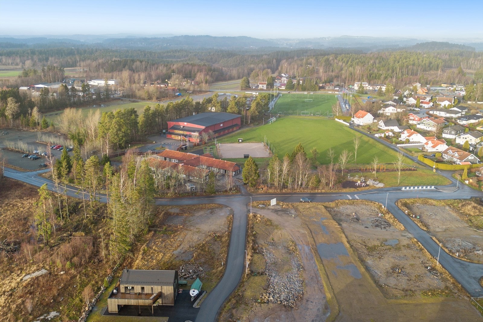 Naboen til idrettsanlegg, legg merke til lekeplassen i forkant, rett ved tomten. Galleribilde