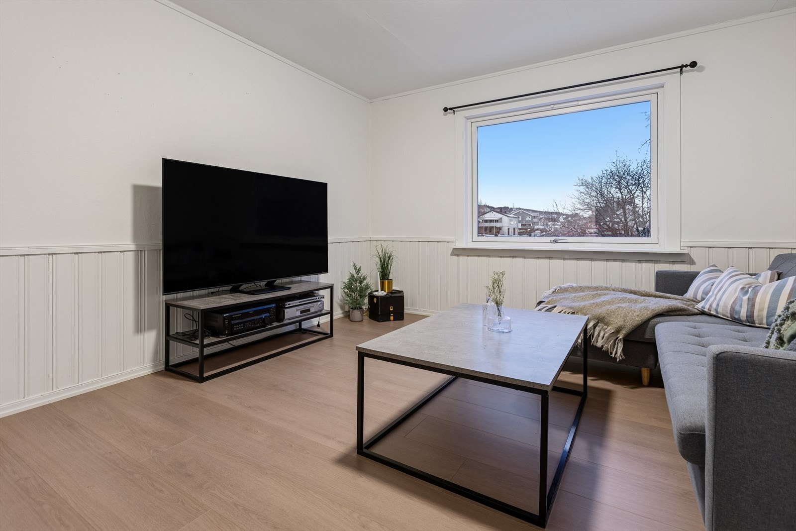 Lys og åpen planløsning på stuen med plass til sofagruppe og TV. Galleribilde