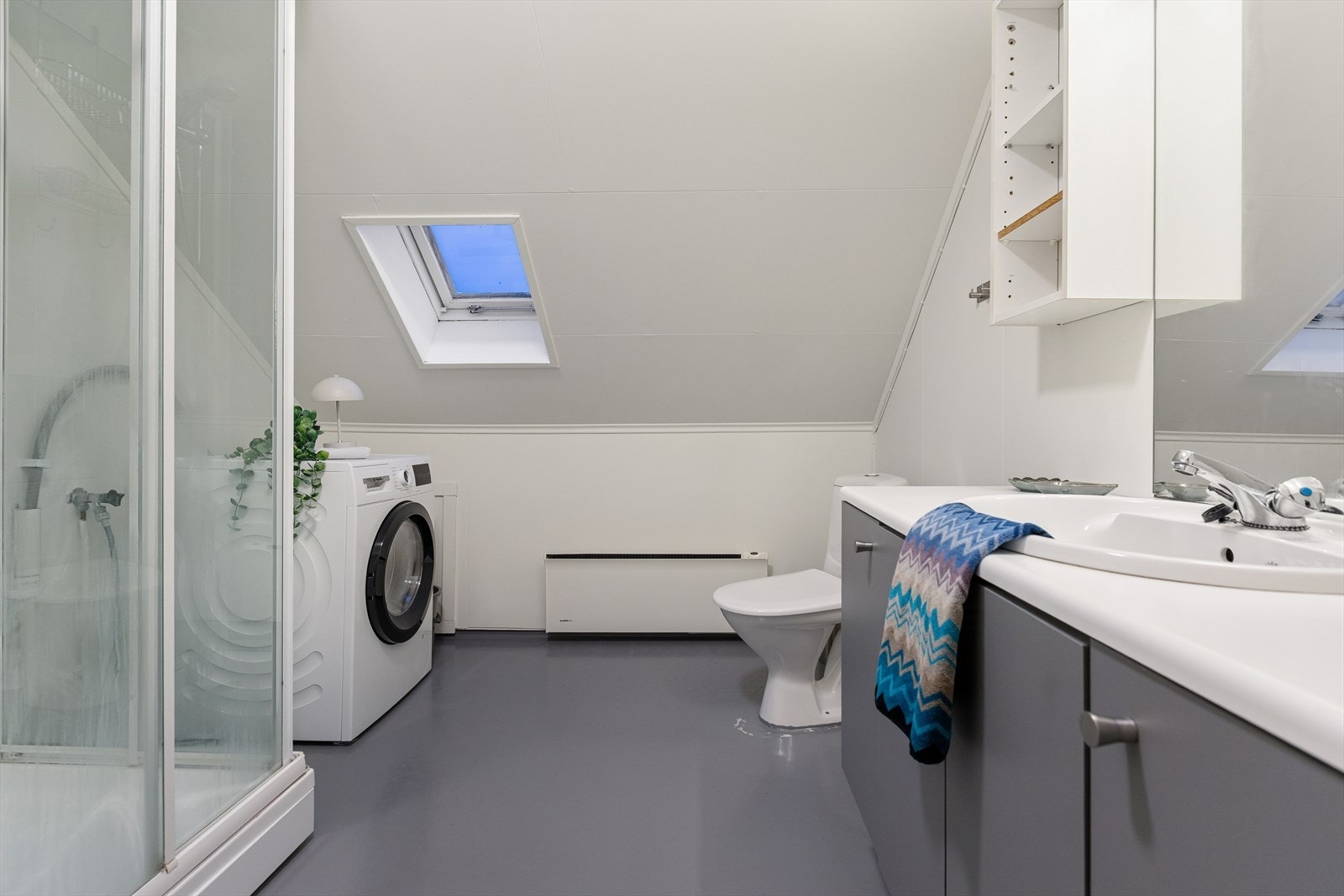 Badet i loftsetasjen har dusjkabinett, wc, servantinnredning og opplegg for vaskemaskin. Galleribilde