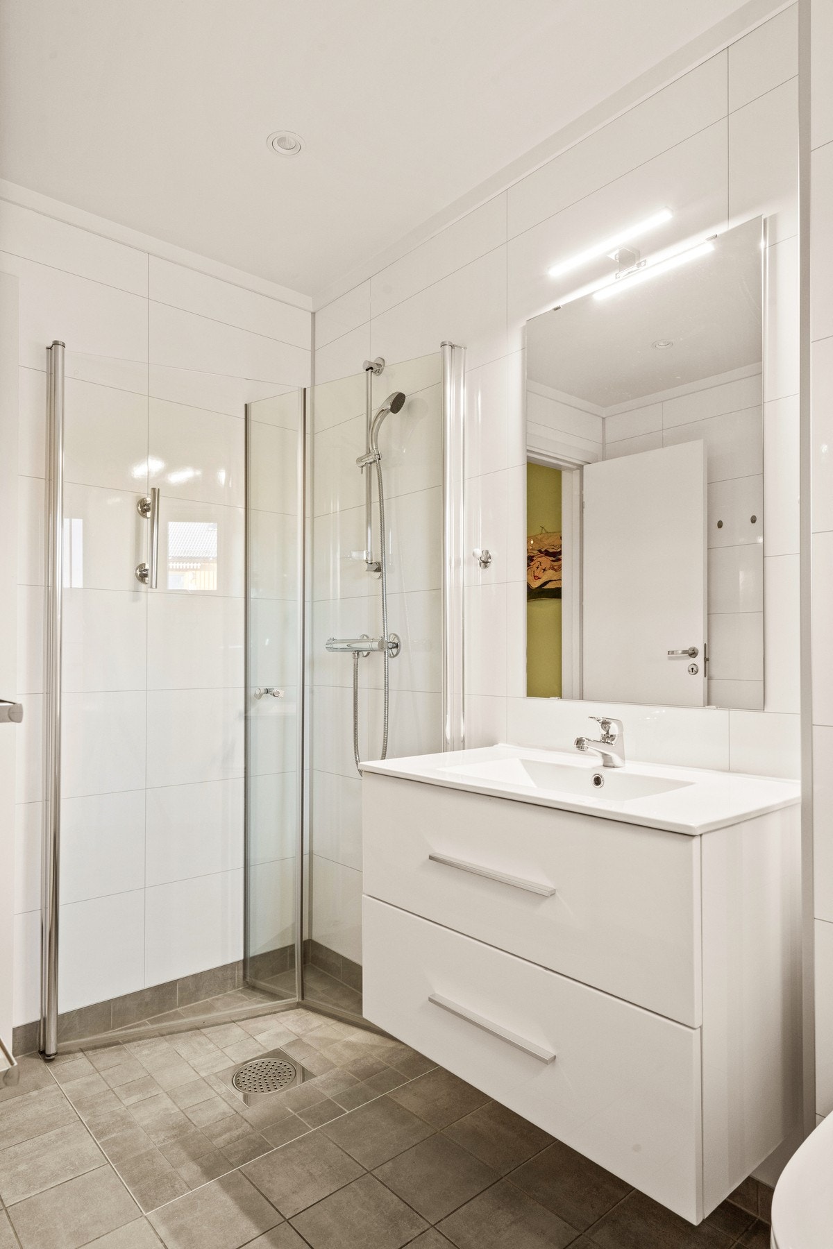 Badet er pusset opp i regi av borettslaget og er innbydende og lyst med varmekabler Galleribilde