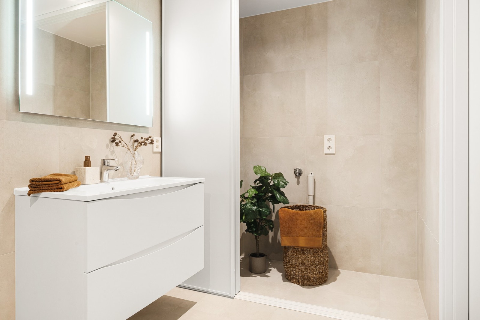 Inneholder moderne innredning som vegghengt toalett, speil, servant m/møbel og plass til vaskemaskin og tørketrommel. Galleribilde