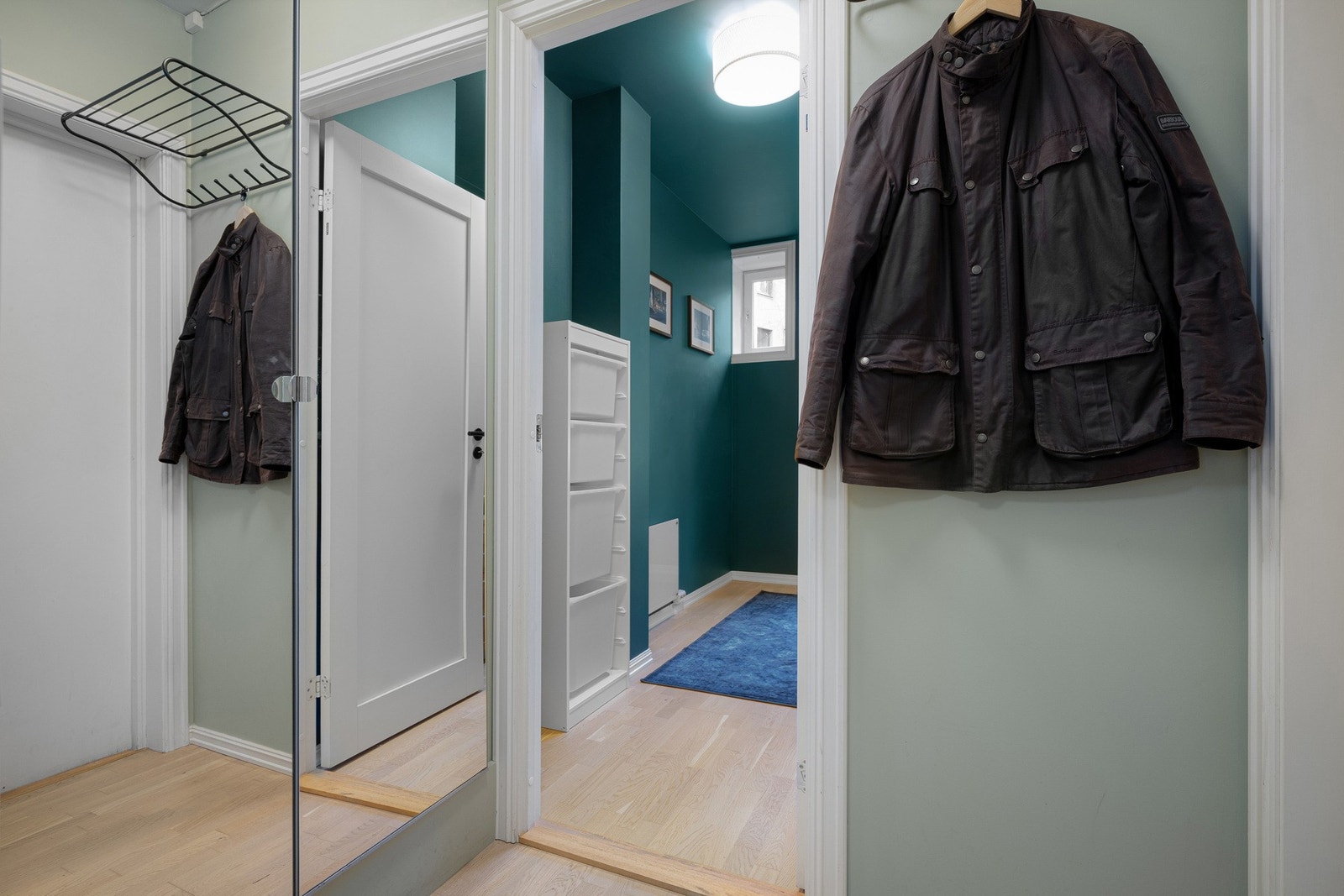 Vel innenfor ligger en hyggelig entré med lyse overflater og integrert garderobeskap med speilfronter. Galleribilde