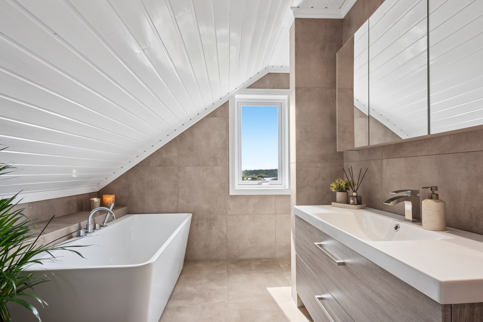 Det andre baderommet er beliggende i boligens andre etasje, praktisk til med soverommene. Baderommet ble pusset opp i 2020, og byr på fliselagte overflater på vegger og gulv. Galleribilde