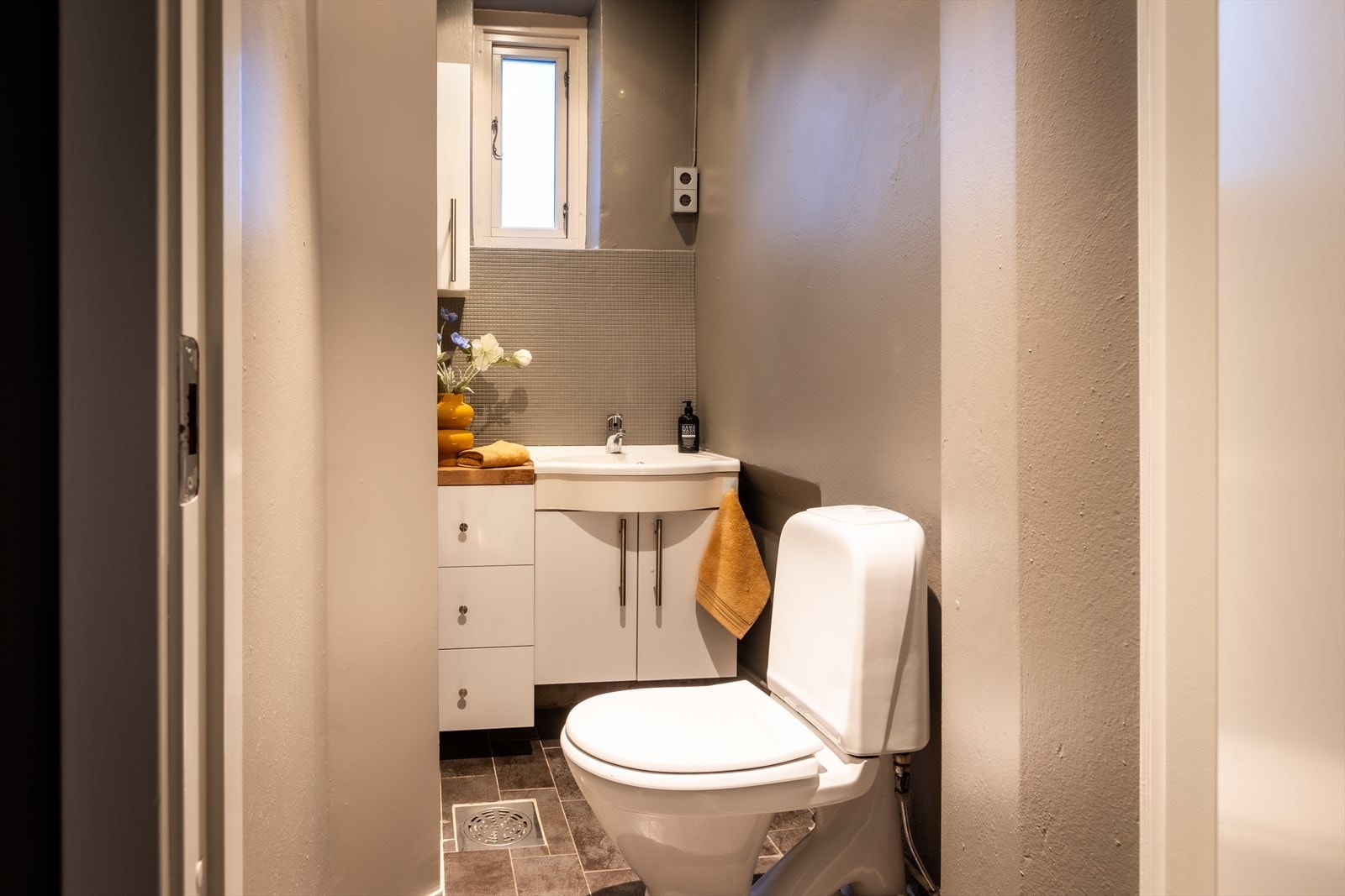 Praktisk gjestetoalett i 1. etasje med servantinnredning og flislagt gulv med varmekabler. Galleribilde