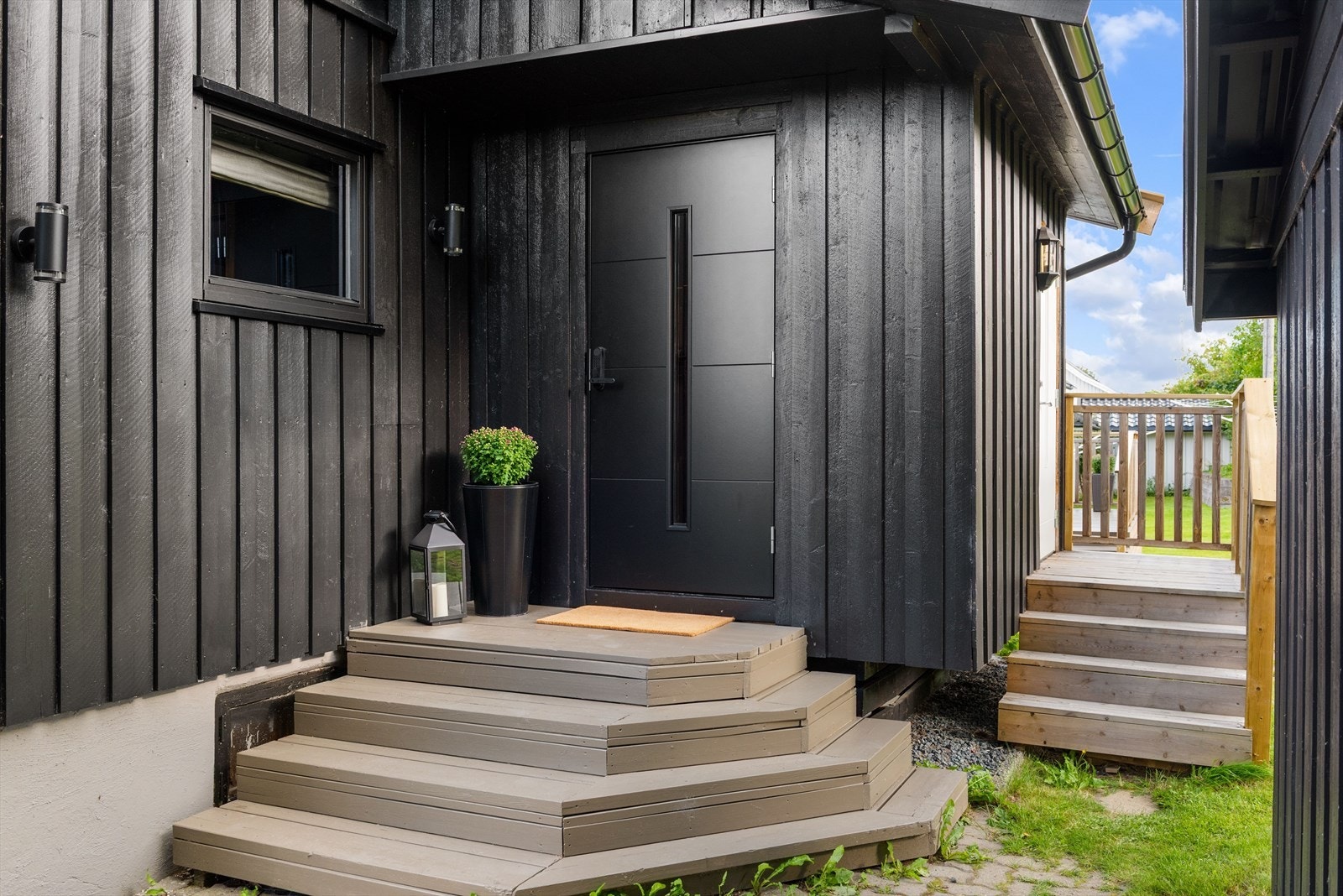 Inngangsparti til 1.etasje med sort dør og inngangsparti til 2.etasje med hvit dør Galleribilde