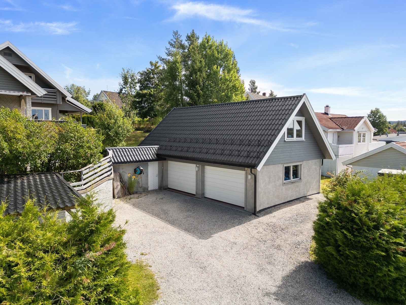 Parkering for en bil i felles garasje. Det er også to plasser oppe ved huset og en ved siden av garasjen. Det er elbil lader plassert ved inngangsdør. Galleribilde