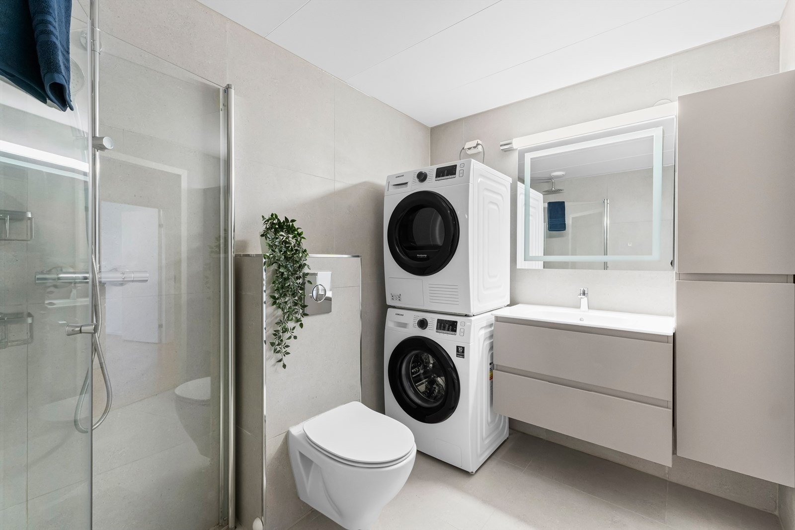 Praktiske innfellbare dusjdører, samt opplegg for vaskemaskin og tørketrommel. Galleribilde