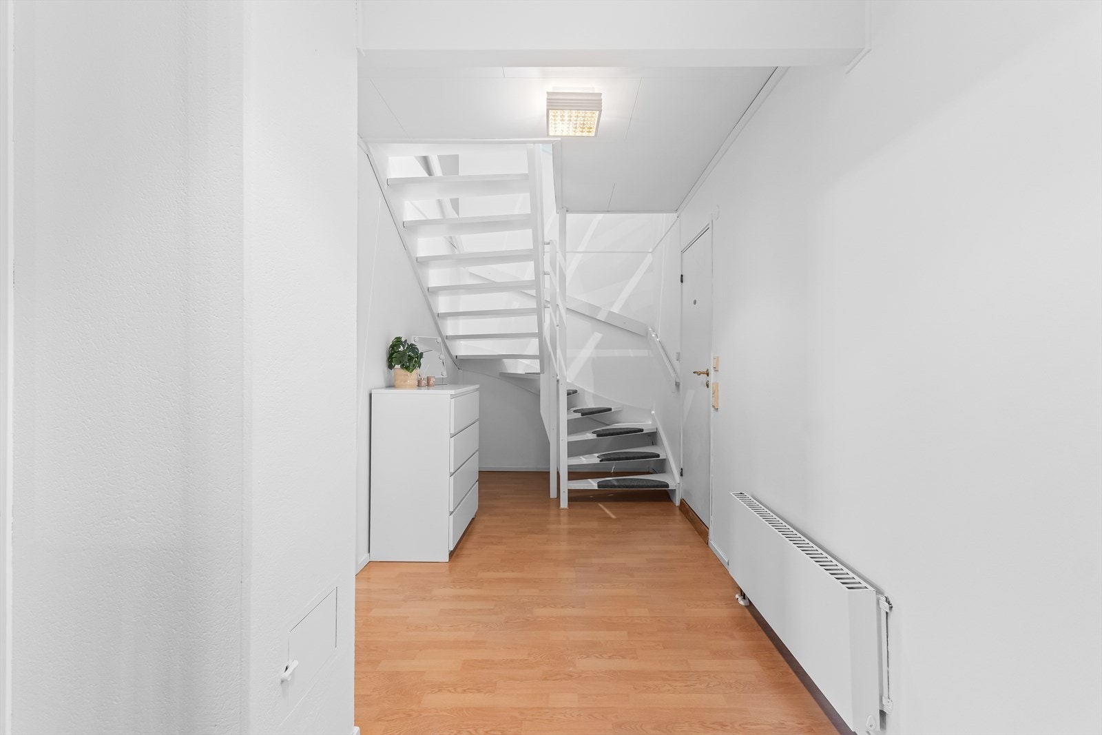 Romslig gang med plass til oppbevaringsmøblement. Radiator med tilknytning til fjernvarme. Galleribilde