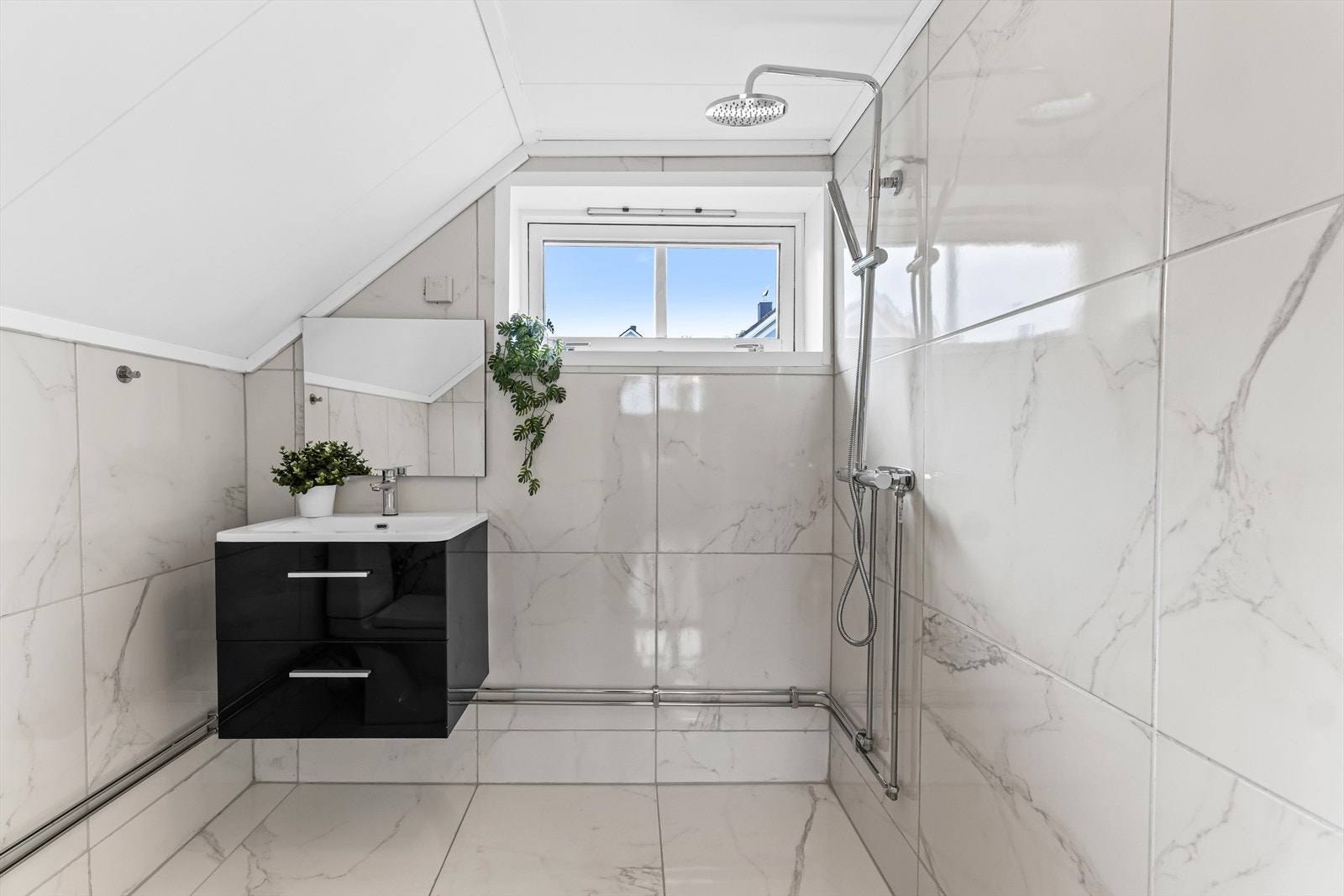 Lyst baderom med flislagte vegger og gulv i overetasjen. Galleribilde