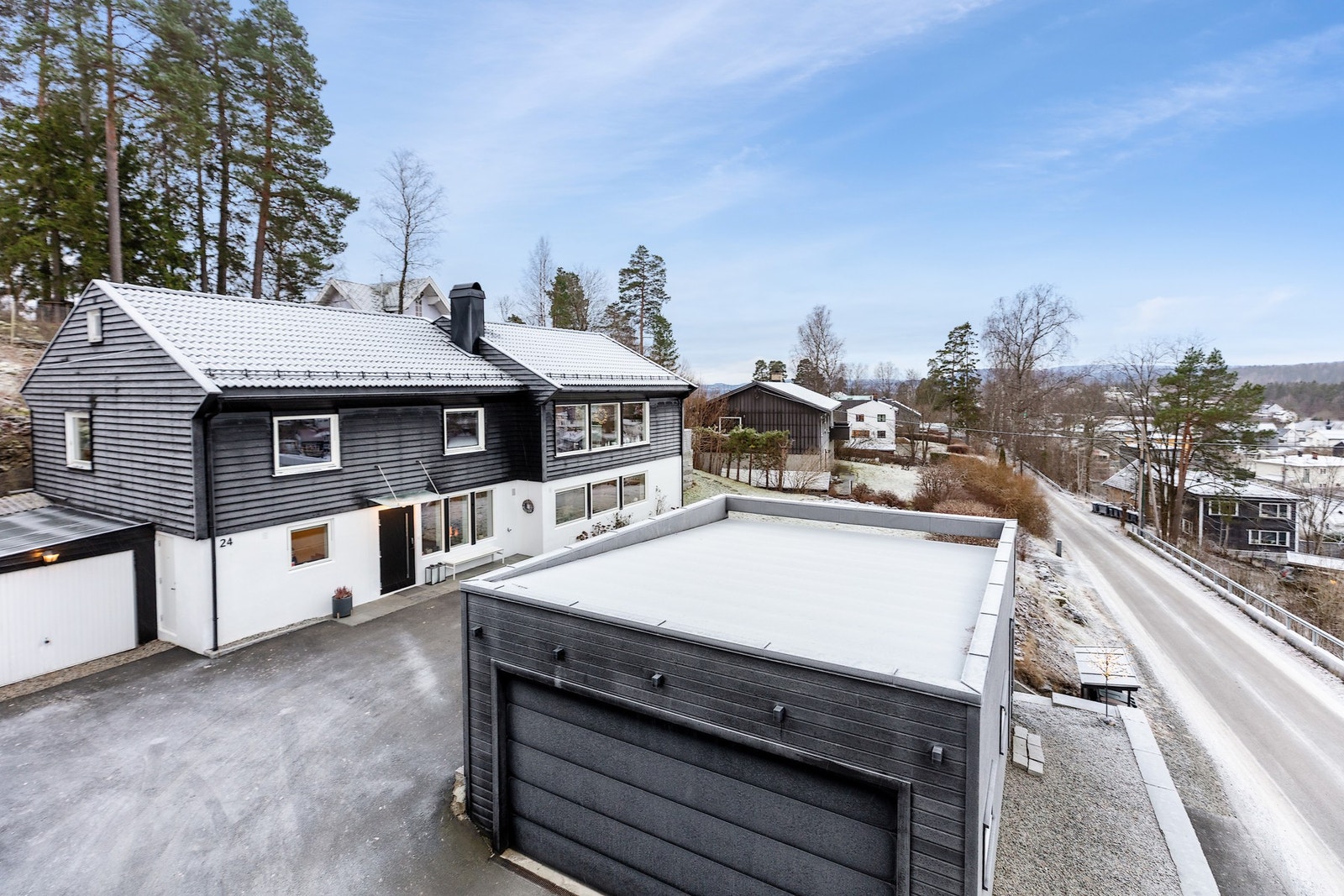 Eiendommen inneholder en stor frittstående dobbelgarasje med elektrisk port. Galleribilde