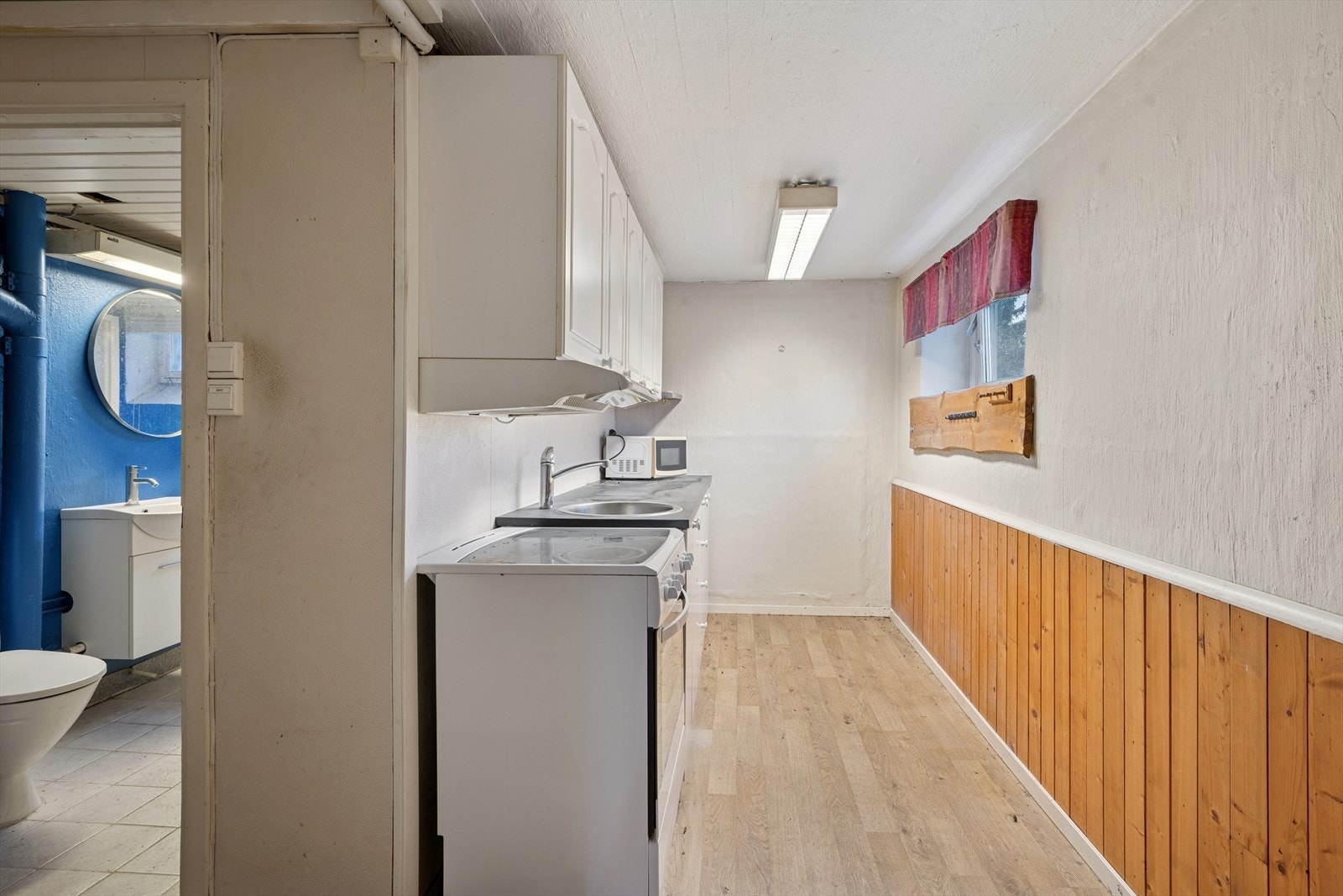 Kjøkkenet i boligens underetasje har en innredning som har både glatte og profilerte fronter, samt en laminatbenkeplate. Galleribilde