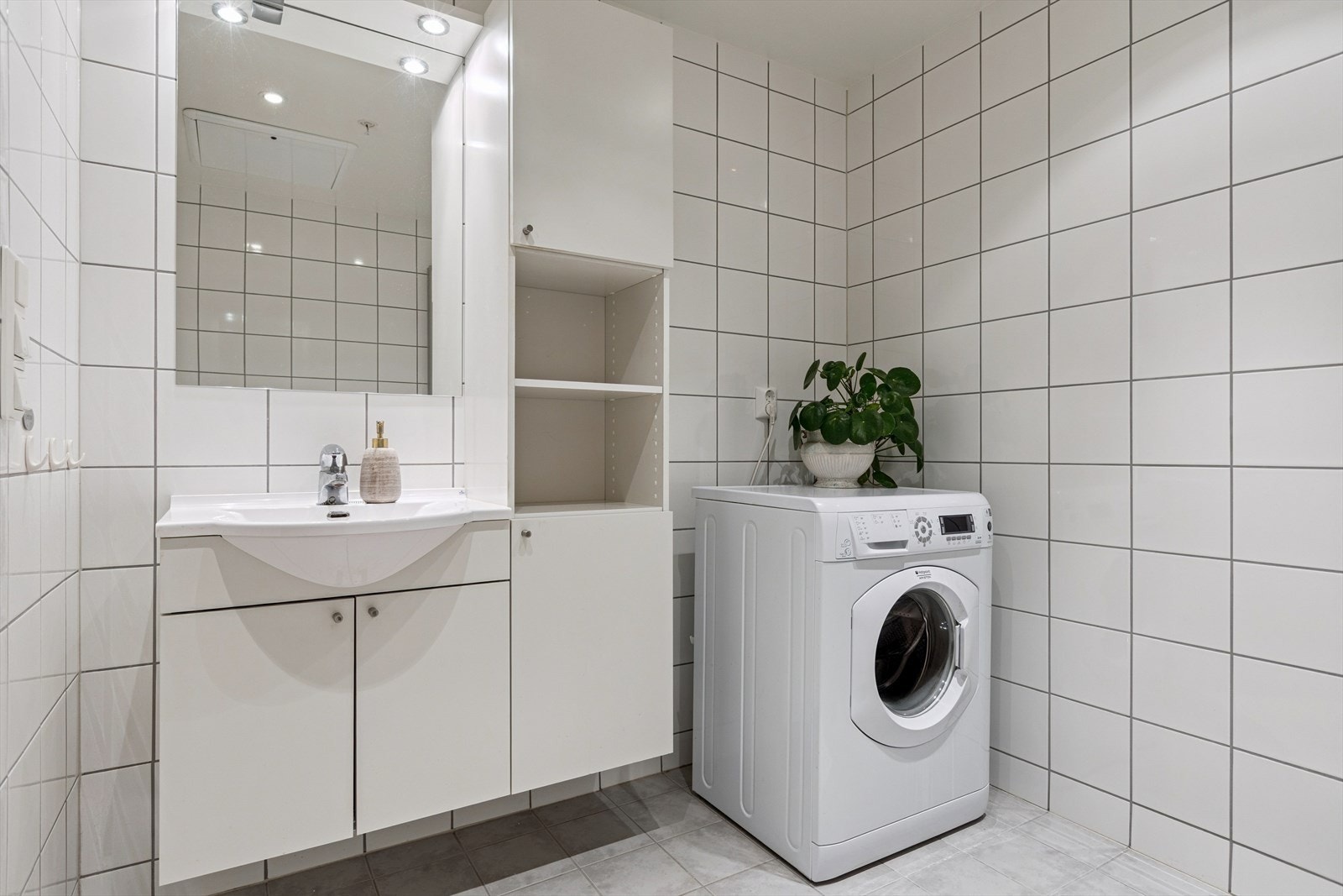 Her har du veggmontert og innredet servant med god oppbevaringsplass, dusj med innfellbare dører, toalett og opplegg for vaskemaskin. Galleribilde