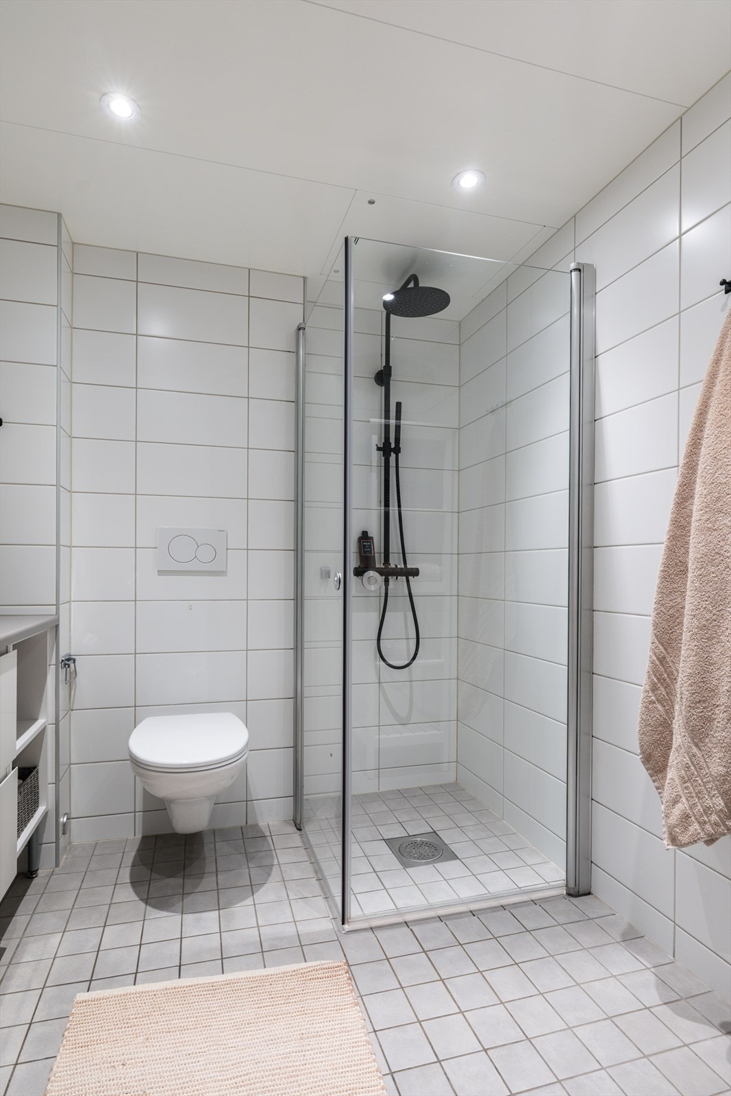 Romslig regnfallsdusj bak innfellbare dusjdører. Galleribilde