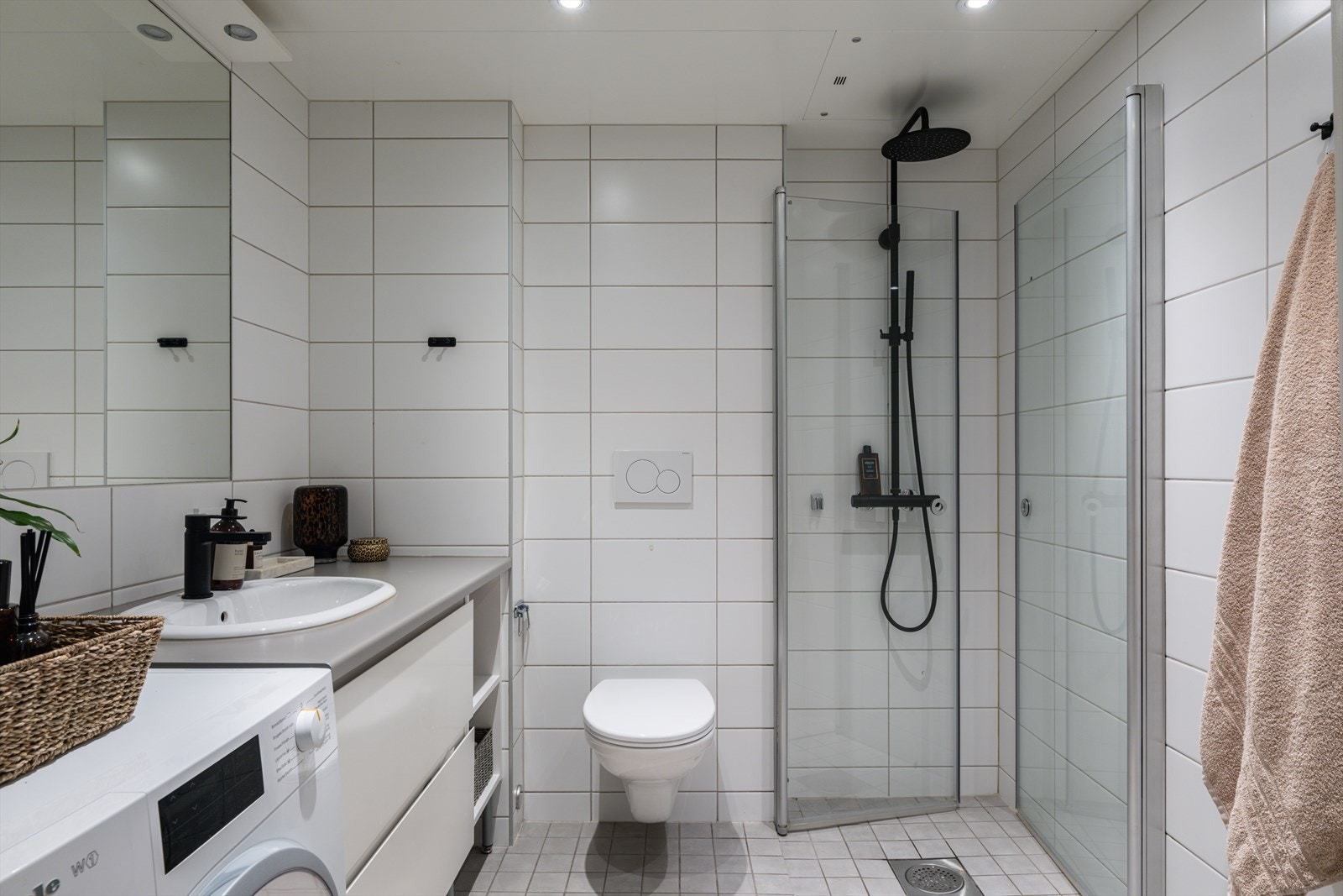 Badet byr på lyse fliser, innfelt belysning og moderne innredning. Galleribilde