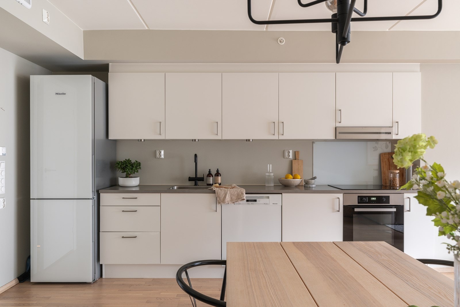 Lyst, tidløst kjøkken med hvitevarer som medfølger. Galleribilde