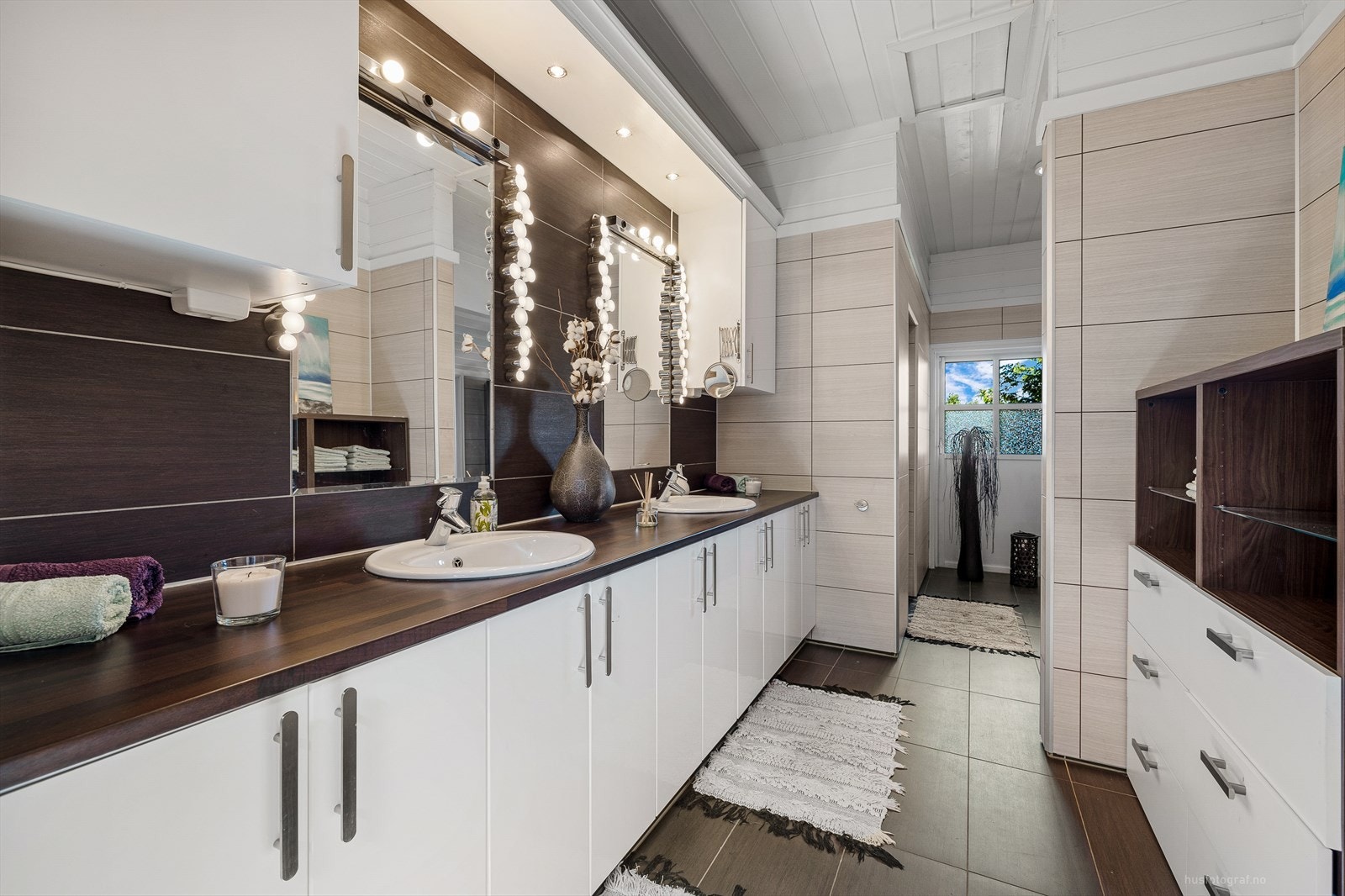 Flott bad overflatepussetopp i moderne tid med fliser på gulv og veggplater. Her finnes rikelig med innredning. Galleribilde