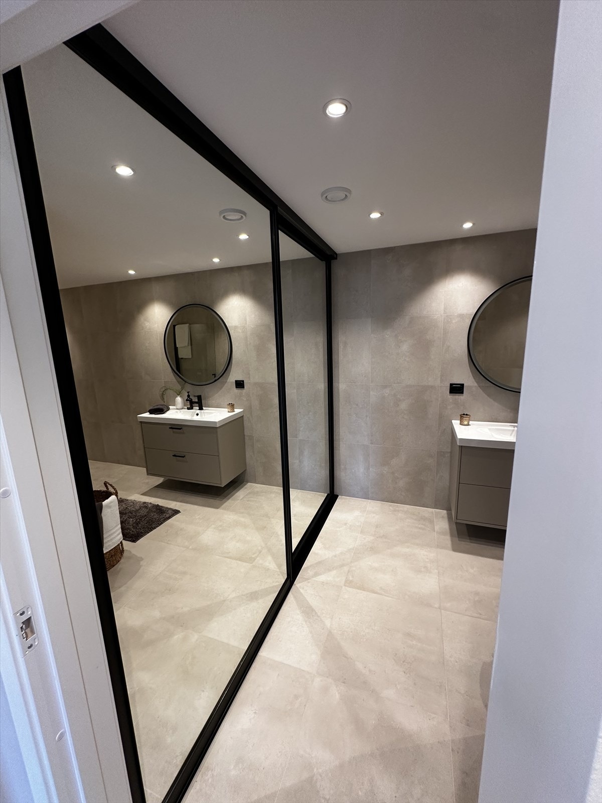 Baderommet har store skyvedører m/speil som skuler opplegget for vaskemaskin og tørketrommel Galleribilde