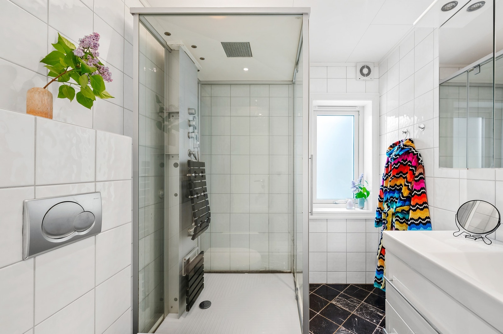 Huset har bad både i første etasje, kjeller og i andre etasje. Badet i første etasje ble pusset opp i 2012 og fremstår tidsmessig med sorte, marmorerte fliser på gulv med gulvvarme, hvite fliser på veggene og downlights i taket. Galleribilde