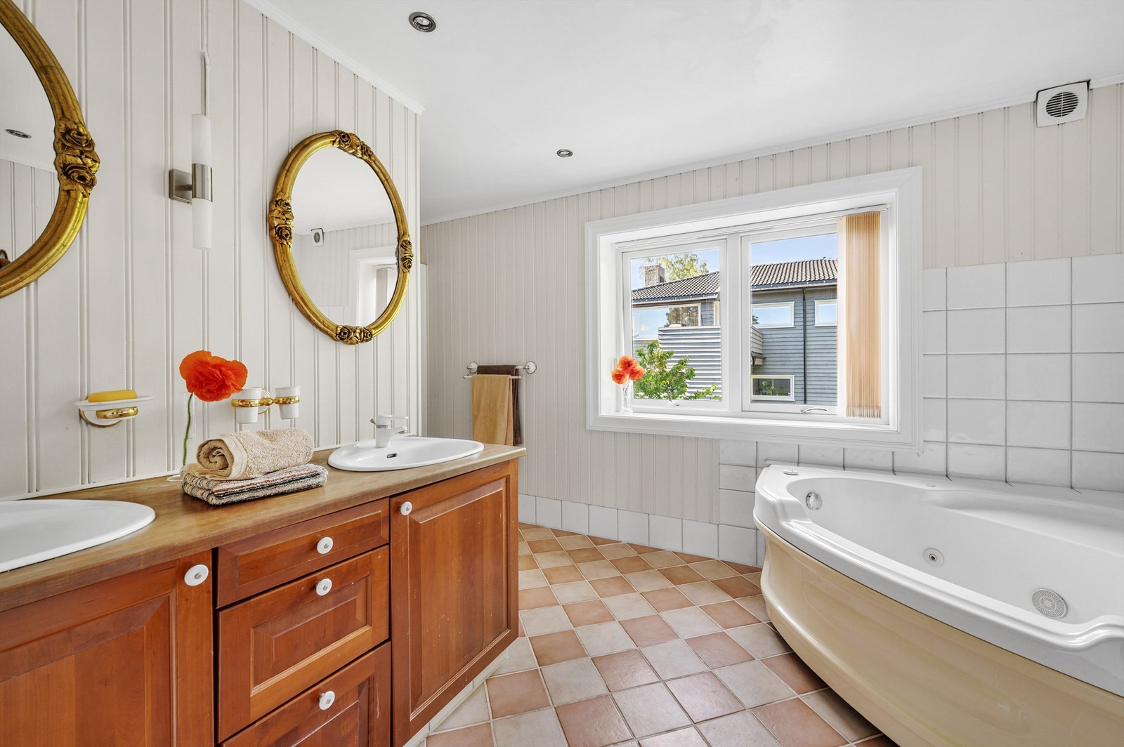 Badet oppe er fra 1997 og har en romslig størrelse med inngang fra to sider og dagslys fra et stort vindu. Rommet har flislagt gulv med gulvvarme, malte panelvegger og hvitmalt himling med downlights. Galleribilde