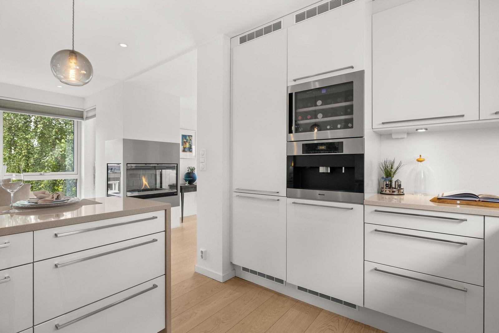 Kjøkkenet har integrert induksjonstopp, stekeovn, kaffemaskin, oppvaskmaskin og kjøleskap med fryser, alle fra Miele. I tillegg er det integrert vinskap fra Liebherr Galleribilde