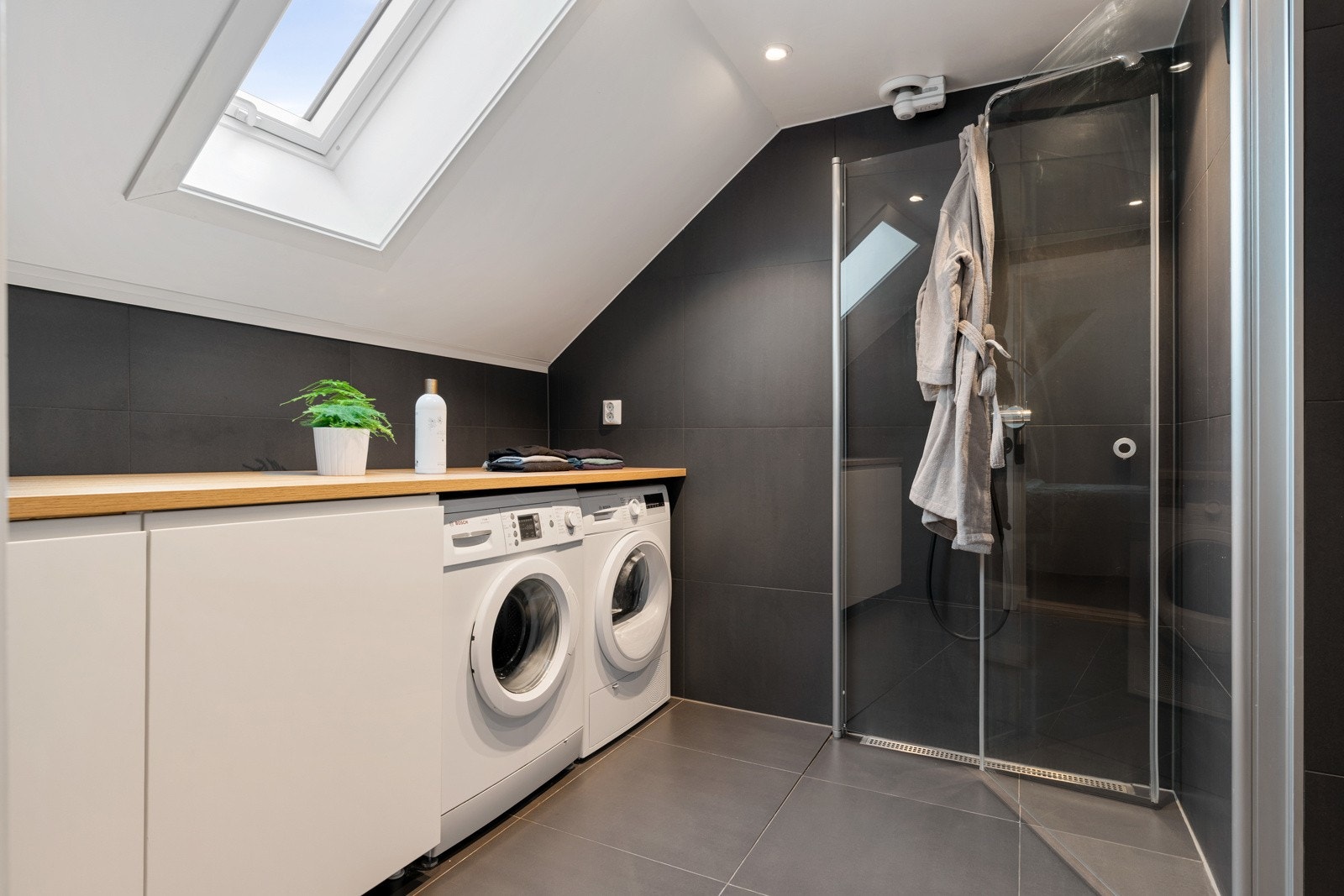 Badet måler romslige 8,5 kvm og har en stor benk med opplegg for vaskemaskin og tørketrommel. Galleribilde