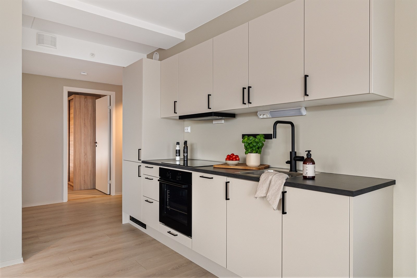 Kjøkkenet har moderne innredning i stilrene farger og integrerte hvitevarer. Galleribilde