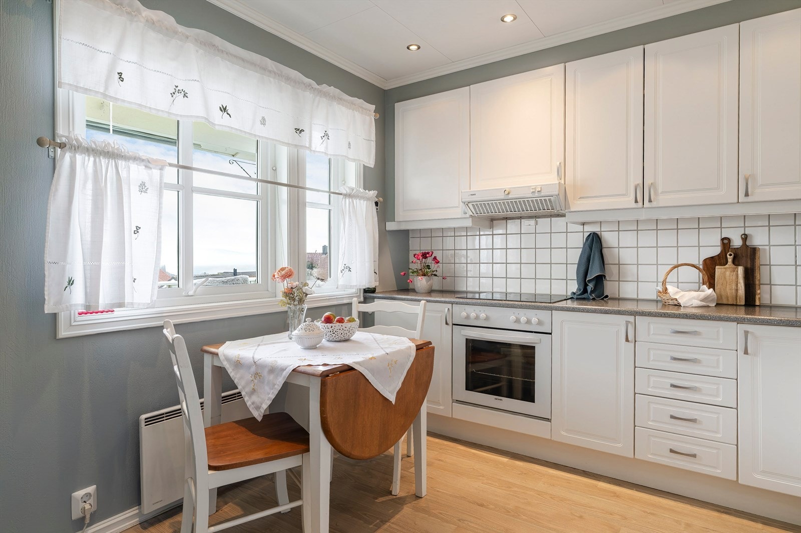 Over benkeflaten er det hvite fliser og underbelysning, og ventilator med avtrekk ut. Komfyr og oppvaskmaskin er integrert, og det er plass til kjøl/frys. Galleribilde