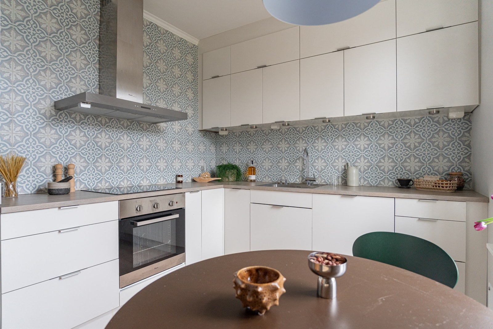 Integrerte hvitevarer, hvite fronter og klassiske fliser på veggene gir et stilrent uttrykk. Galleribilde