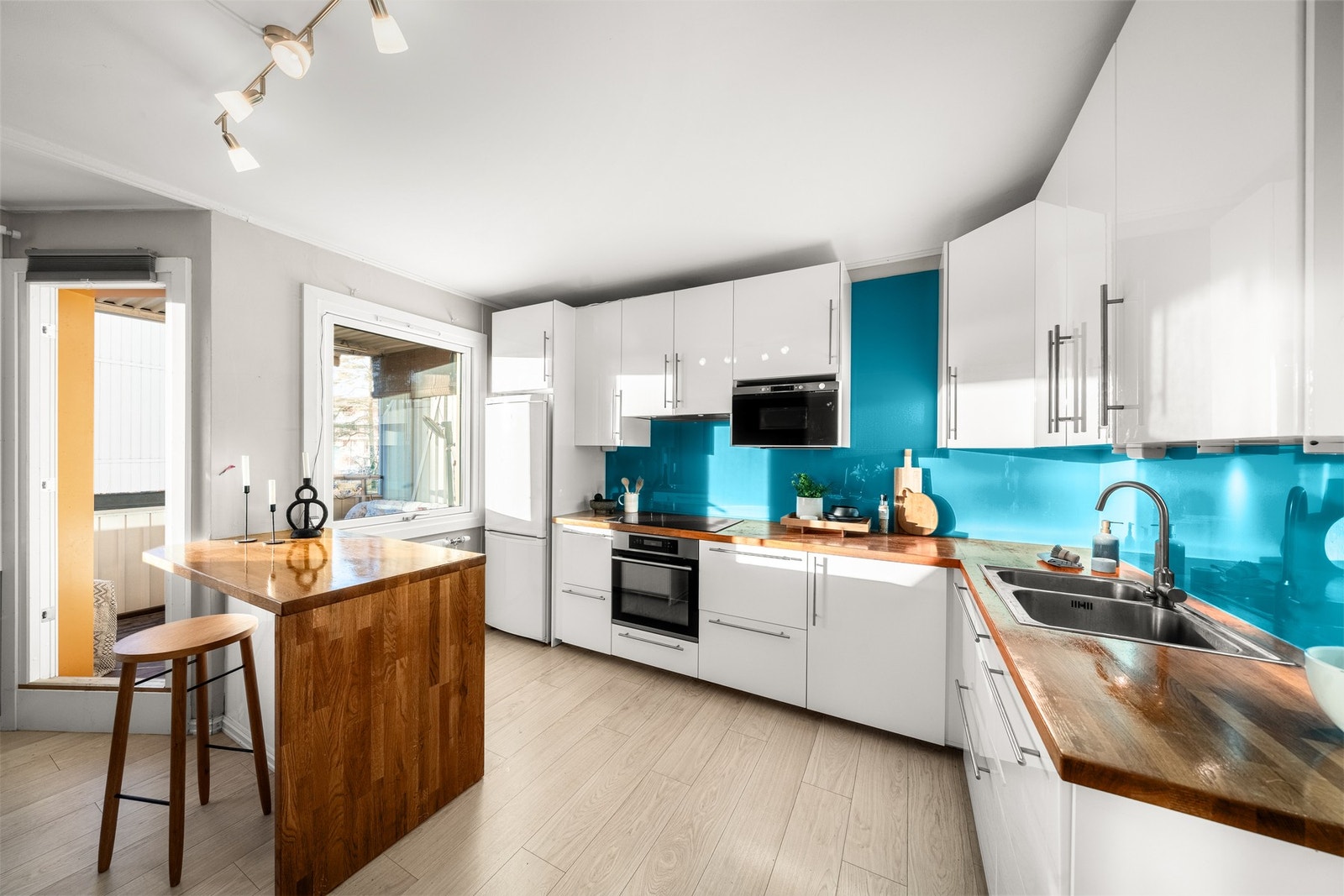 Takhøy og stilren kjøkkeninnredning med slette fronter og praktisk kjøkkenøy. Galleribilde