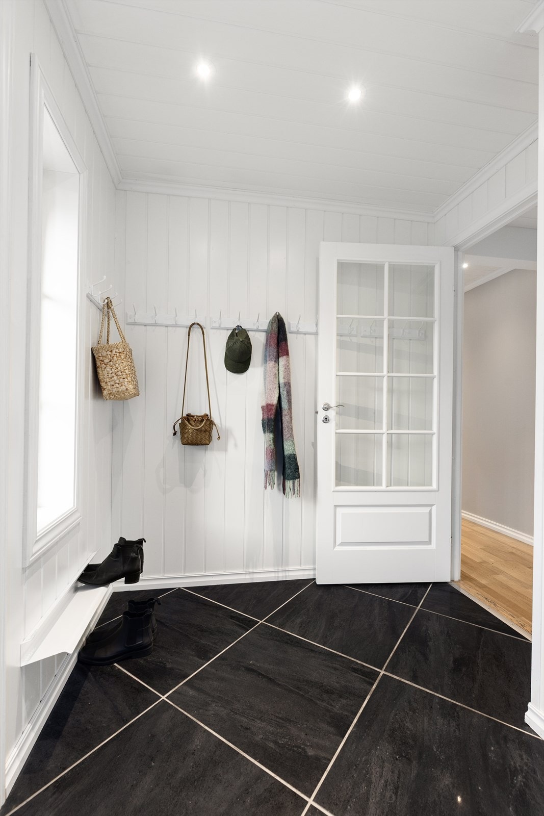 I entré er det pene overflater med flis på gulv, malt mdf- panel på vegg samt malt mdf- panel med spotter i himling. Galleribilde