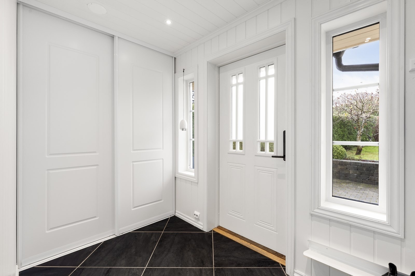 Lys og innbydende entré med praktisk skyvedørsgarderobe med god plass til yttertøy. Tilbygget i 2014. Galleribilde