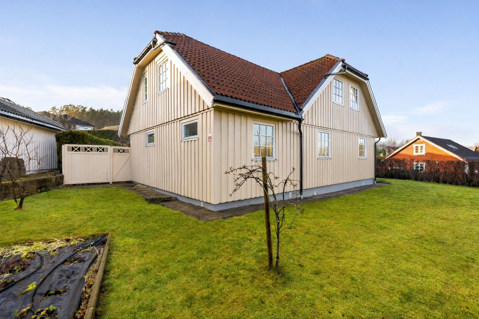 Tomten er på 836,1 m. Det er etablert en koselig jordbæråker på enden av tomten som du ser til venstre i bildet - en hage til glede for store og små! Port fra hagen og inn til uteplassen ved inngangsparti. Galleribilde