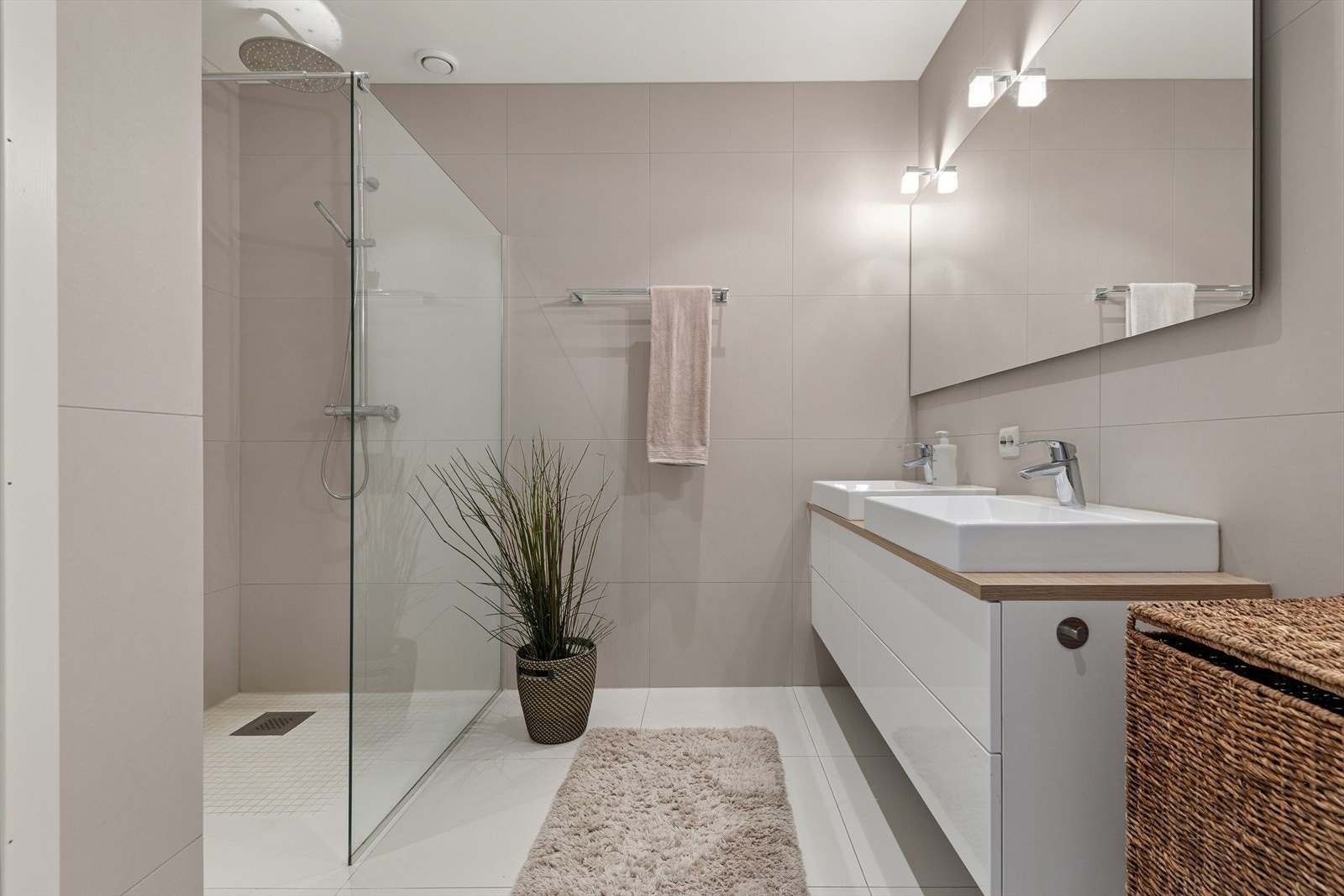 Moderne og stilrent bad med store fliser, dusjhjørne med glassvegg og dobbel servant. Ferdige bokser for feks. Sonos gir mulighet for integrert lydsystem. Galleribilde