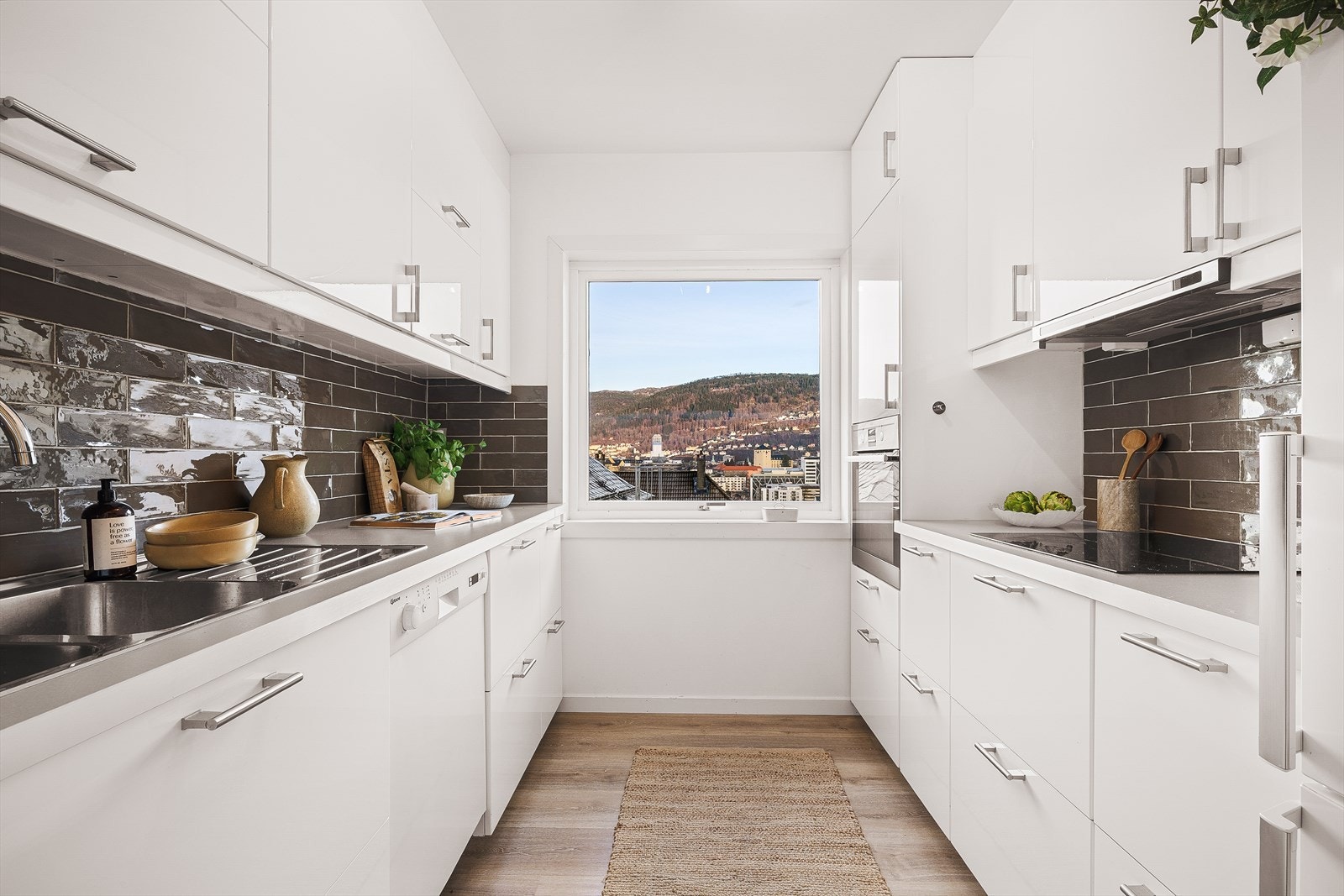 Kjøkkenet har slette hvite fronter fra IKEA og benkeplate av laminat med nedfelt stålvask. Galleribilde