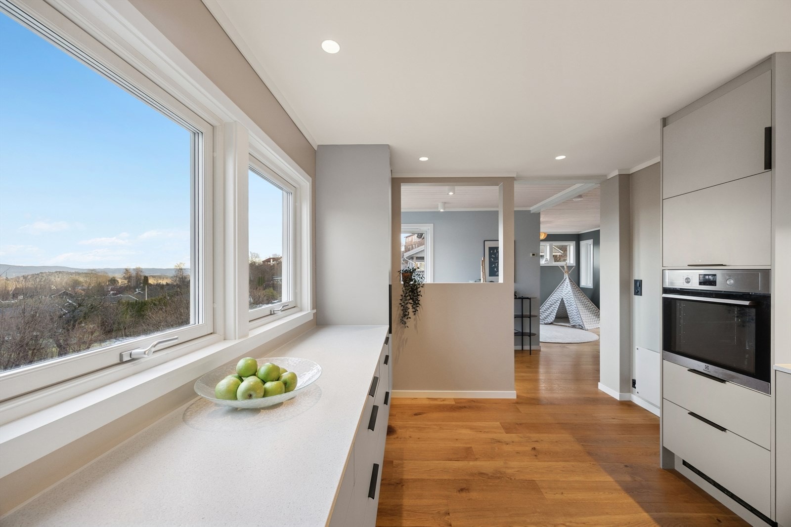 Fra kjøkkenvinduene er det utsyn mot grøntområder, som gir en lys og åpen følelse. Galleribilde